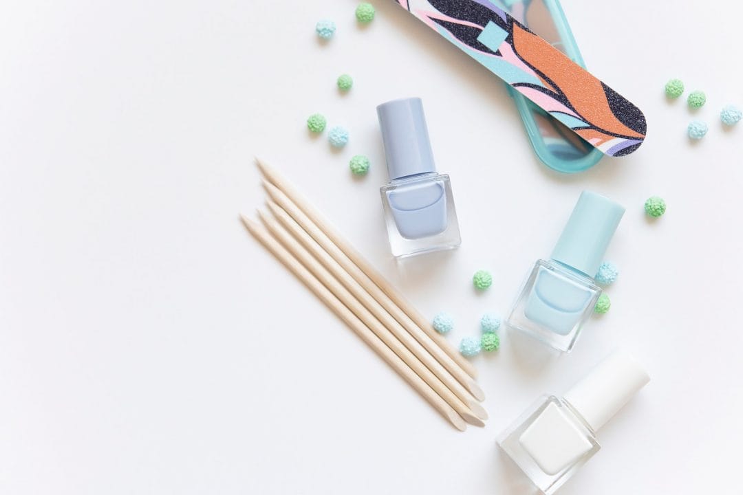 Nail polish bottles, wooden sticks, and nail art tools for manicure.